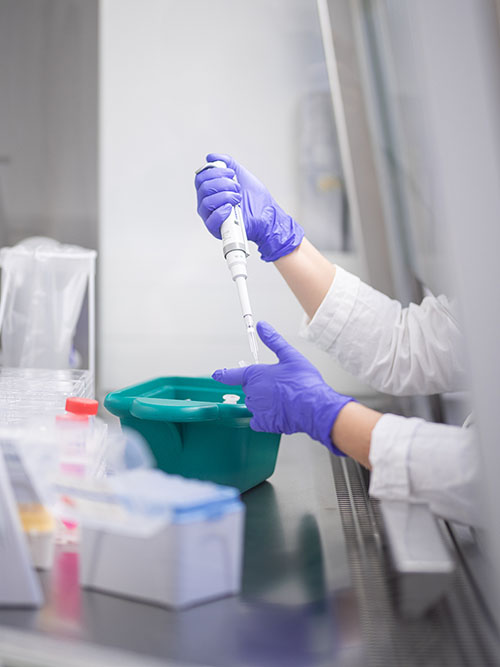 Scientist using pipette in laboratory.